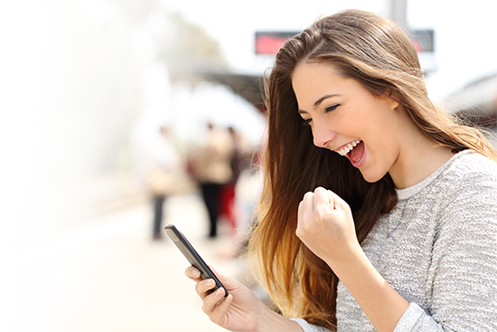 Person joyfully using a smartphone in public