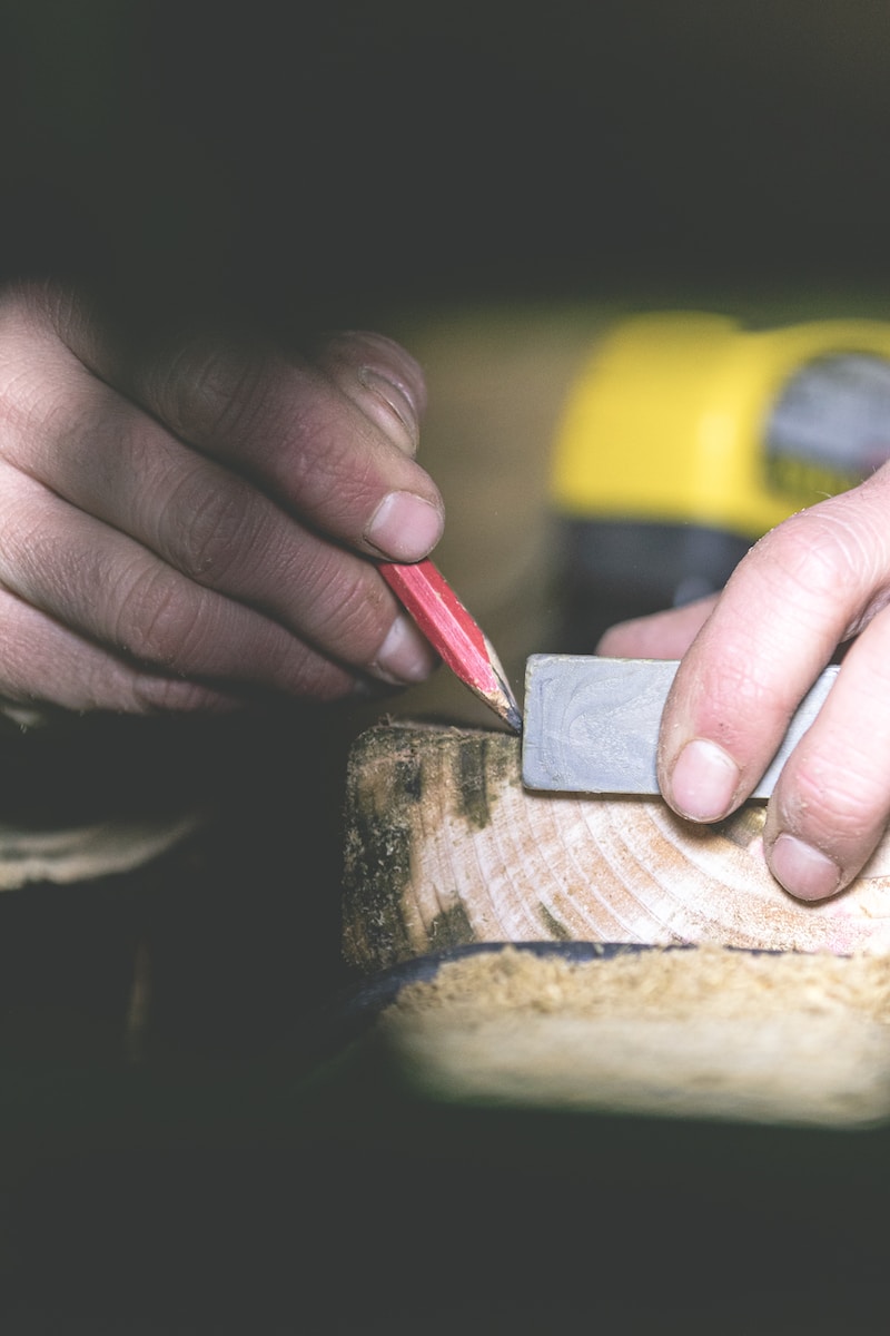 contractor marking a piece of wood with a pencil